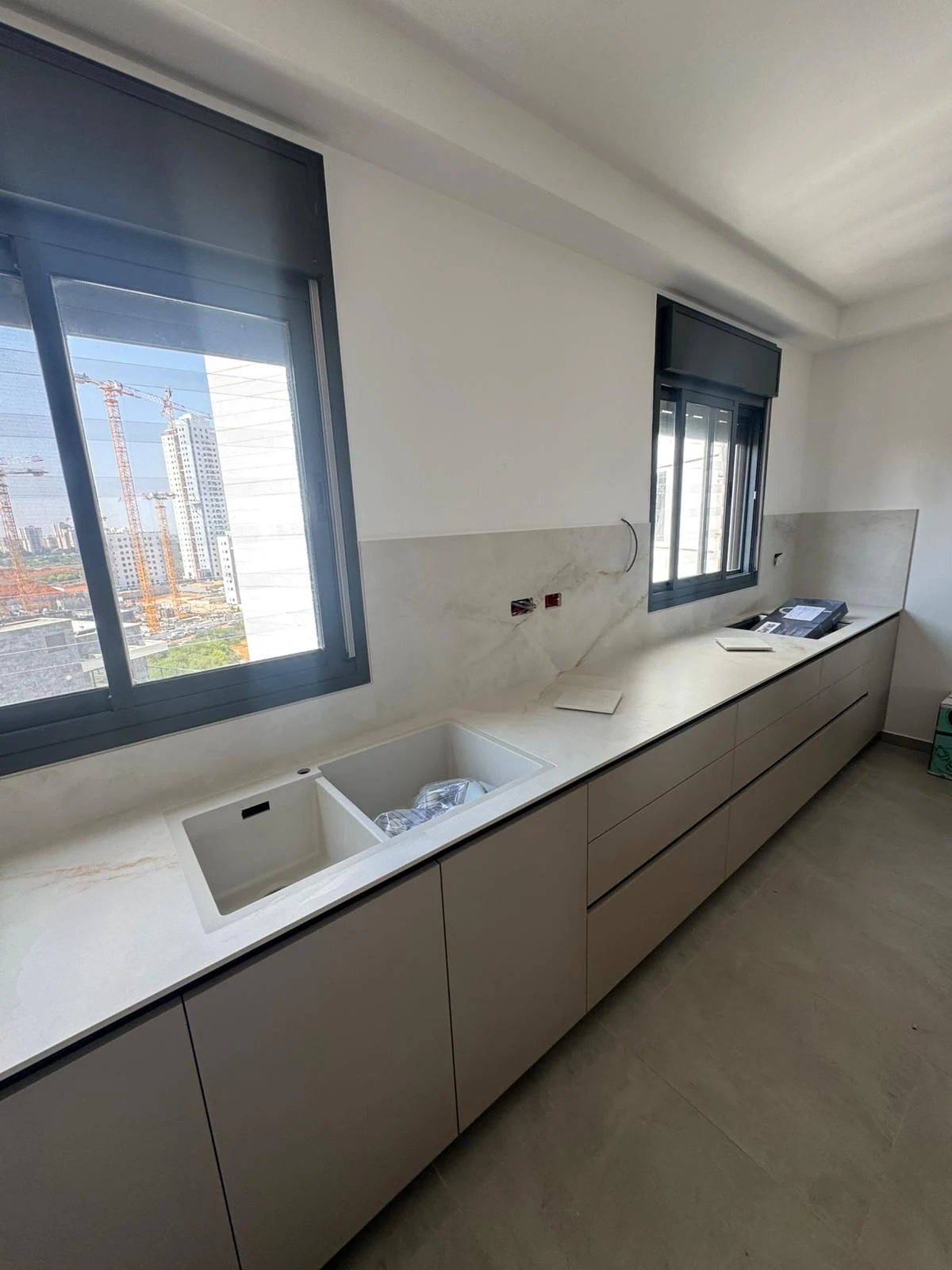 משטח עבודה בהיר מדגם Onice White 155 ASCALE לאורך חזית המטבח