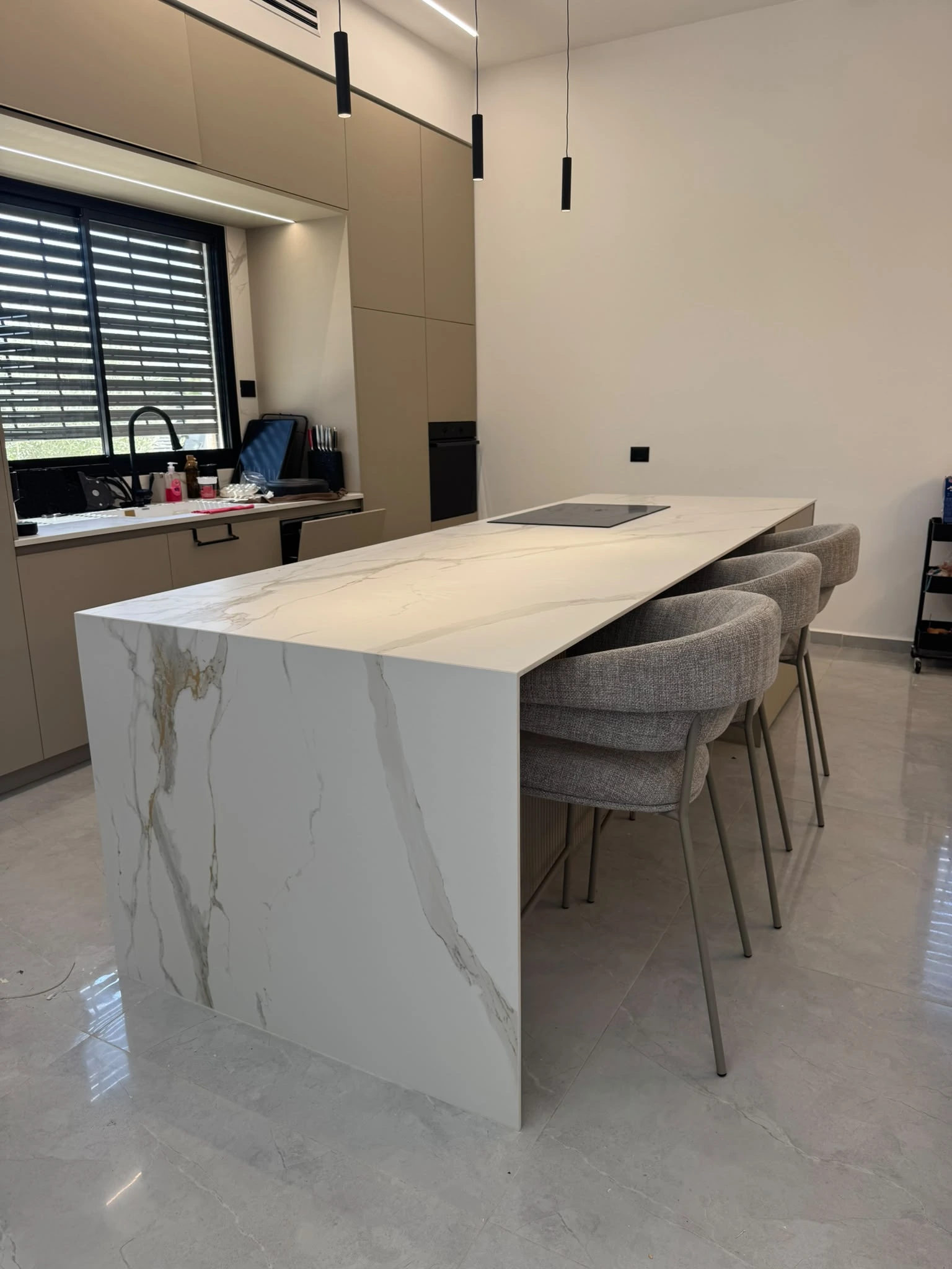 מטבח בהיר באופקים עם אי גדול ומשטח Calacatta Oro MB06 INFINITY