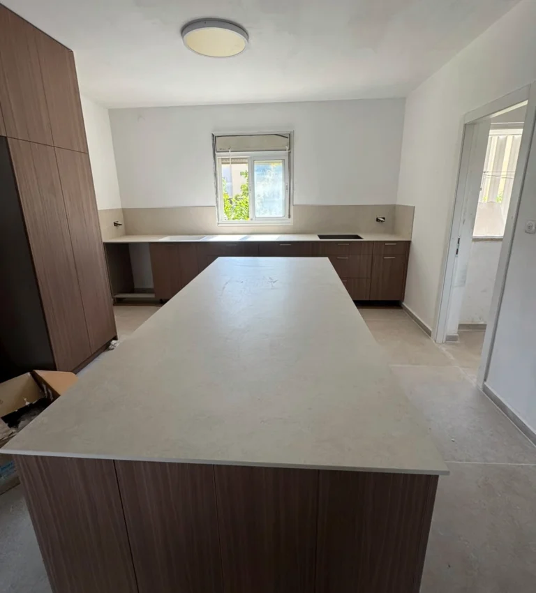התקנת Chianca di Ostuni SE01 INFINITY במטבח עם אי וכיור מתחת לחלון במודיעין