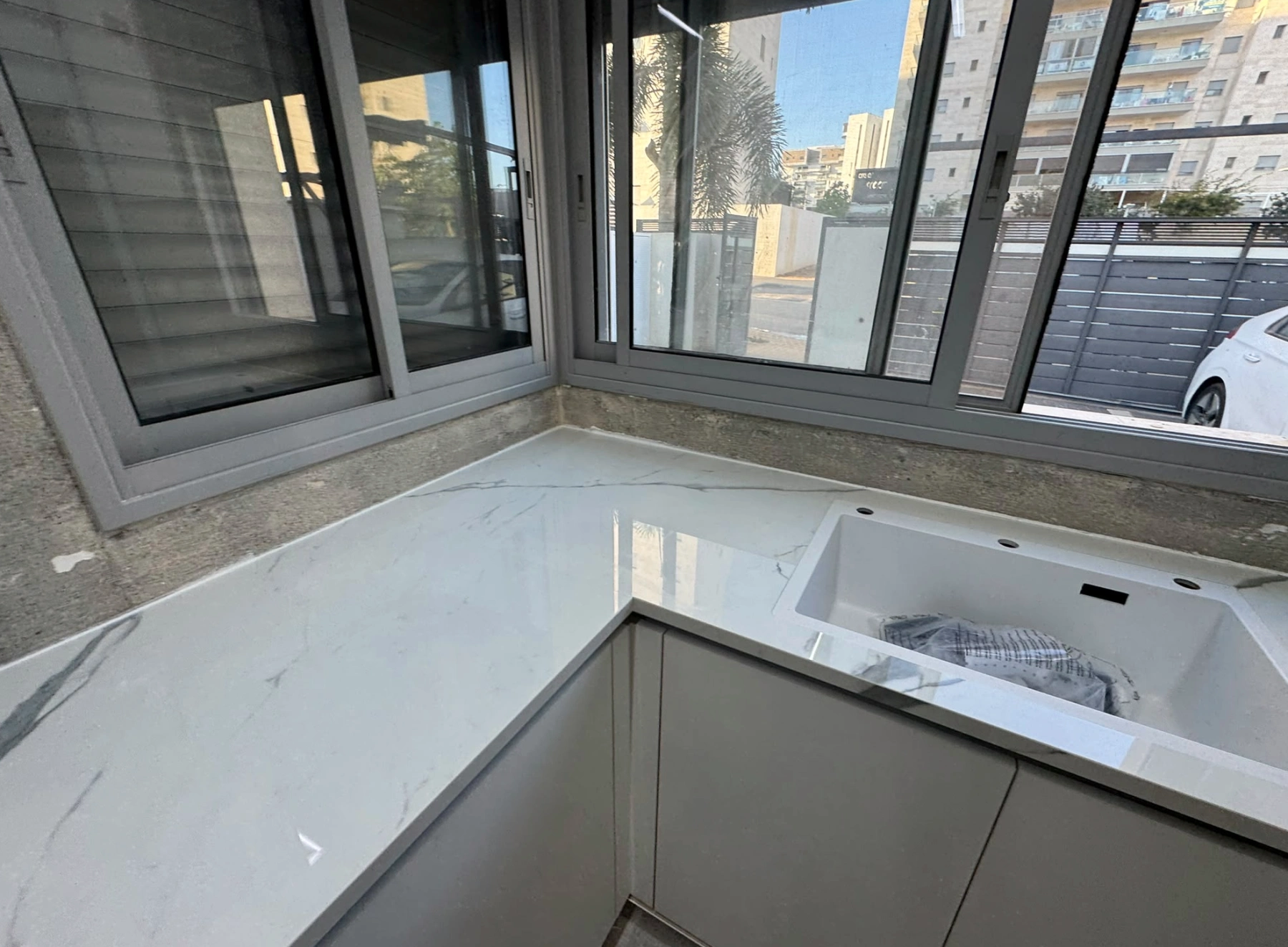 משטח NUOVO CORSO מבריק באזור הכיור והחלון במטבח בשדרות