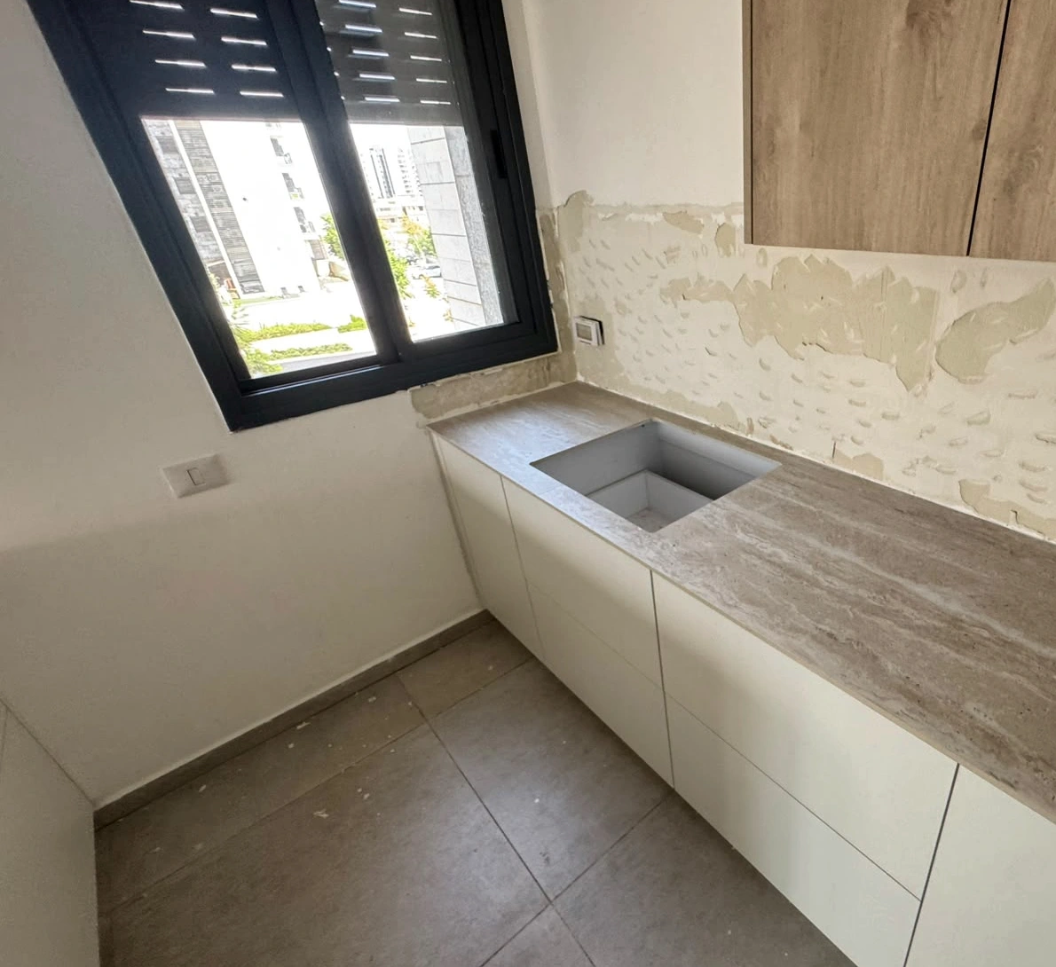 משטח TIVOLI WHITE 121 ASCALE עם כיור מתחת לחלון במטבח בנתיבות