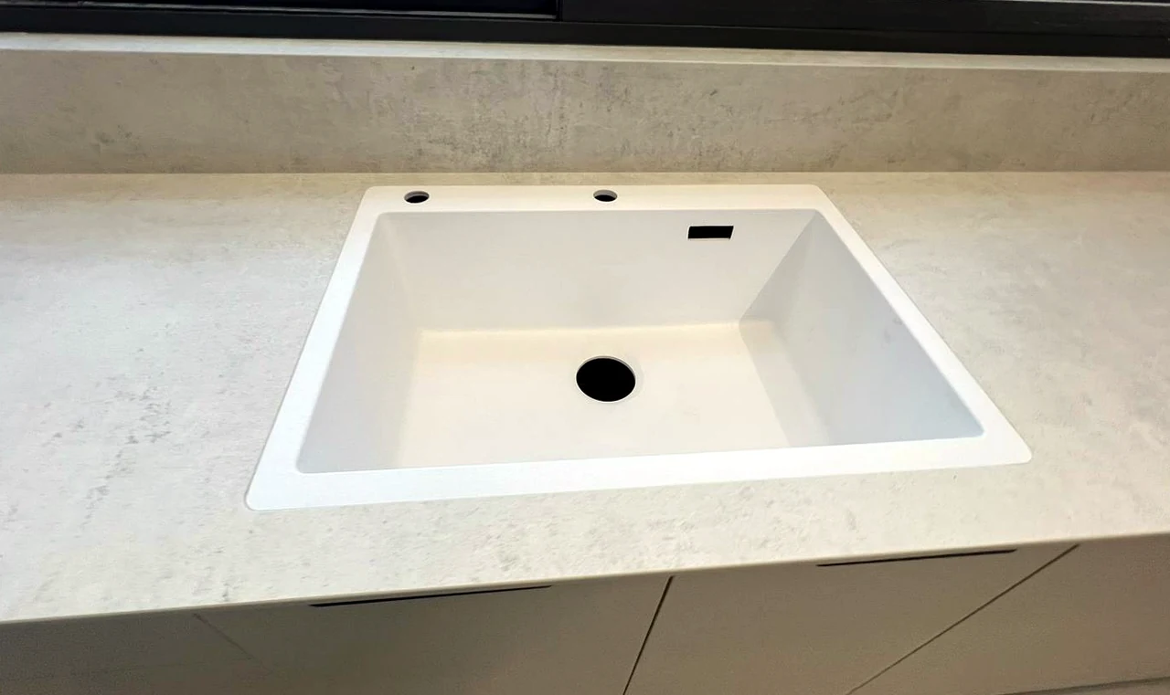 כיור לבן שקוע בתוך משטח DEKTON LUNAR 12MM באופקים